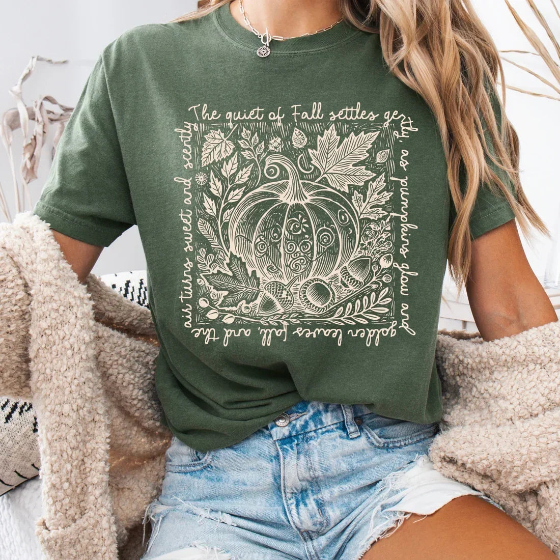 Woman wearing a green Comfort Colors fall pumpkin graphic t-shirt with an autumn leaf design