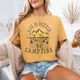 Soft cotton short sleeve T-shirt with “Life Is Better By A Campfire” with an image of a campfire with the mountains in the background. 