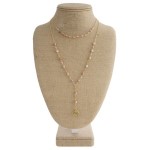 Gold tone layered necklace with natural stone and boho charm.