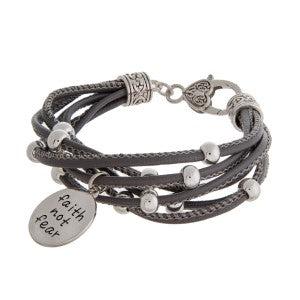 Faux leather bracelet with silver tone beads, a lobster clasp, and a stamped charm.