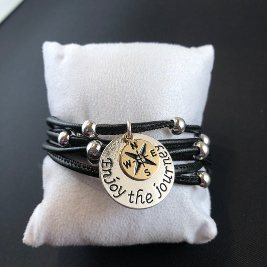 Faux leather bracelet with silver tone beads, a lobster clasp, and a stamped charm.