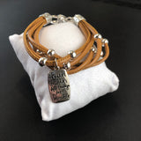 Faux leather bracelet with silver tone beads and a stamped charm.