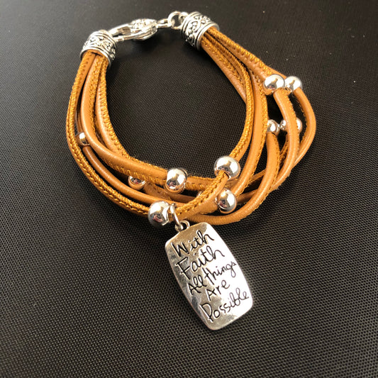 Faux leather bracelet with silver tone beads and a stamped charm.