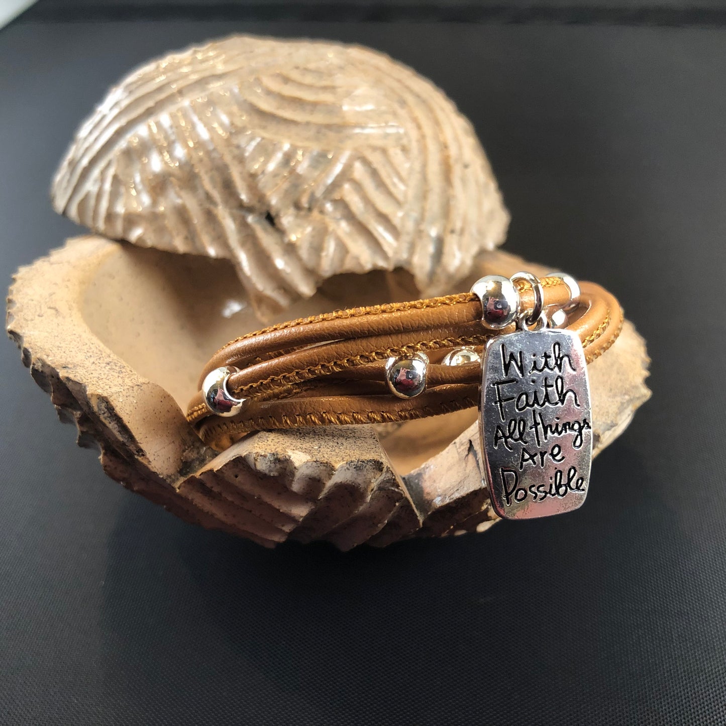 Faux leather bracelet with silver tone beads and a stamped charm.