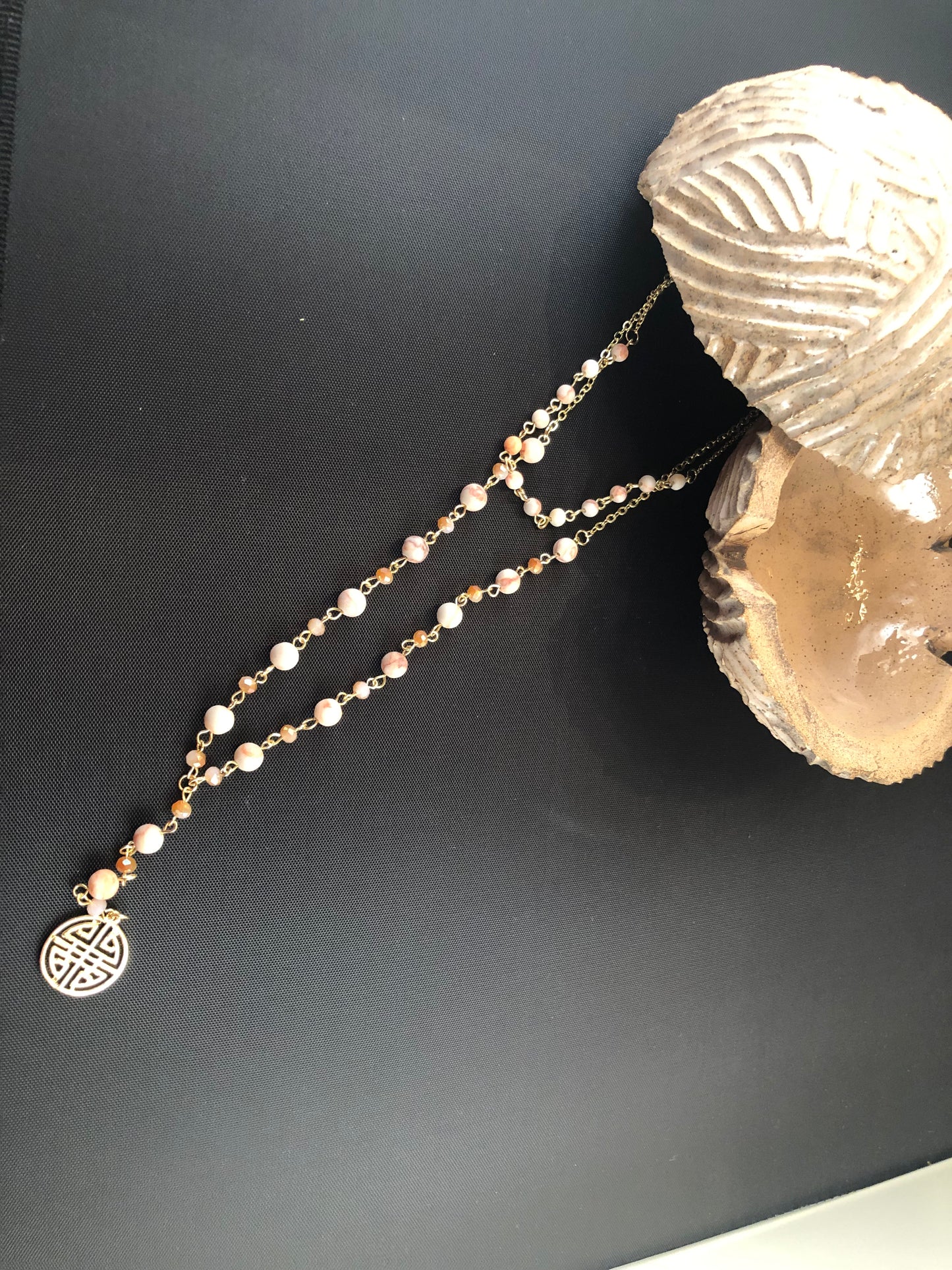 Gold tone layered necklace with natural stone and boho charm.