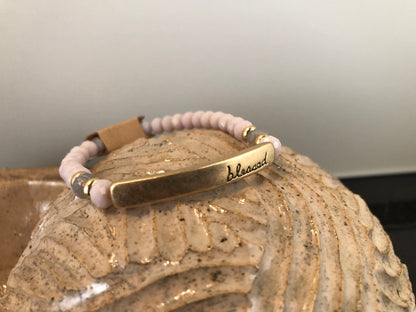 Beaded stretch bracelet with a bar focal, stamped with "blessed."