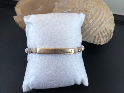 Beaded stretch bracelet with a bar focal, stamped with "blessed."