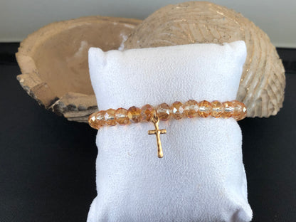 Stretch bracelet with faceted beads and cross charm.